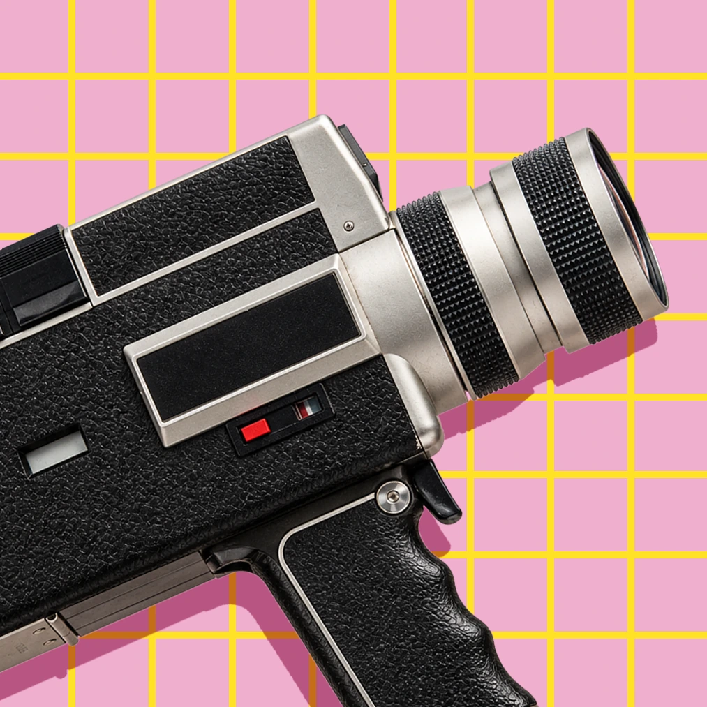 Caméra Super 8 vintage sur fond rose quadrillé